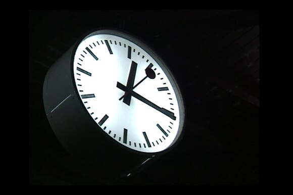 Un orologio di stazione svizzera ripreso in piena notte: si vedono solo quadrante e lancette