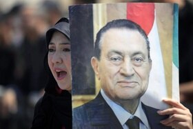 Un ritratto di Mubarak mostrato da una sua sostenitrice nel 2013 durante i processi contro l ex presidente.