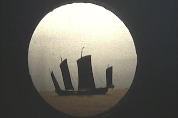 La silhouette di un imbarcazione vista attraverso un oblò.