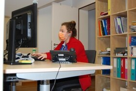 una giovane scrive con un computer.