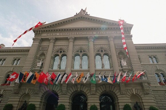 Swiss parliament building decorated with flags of the cantons