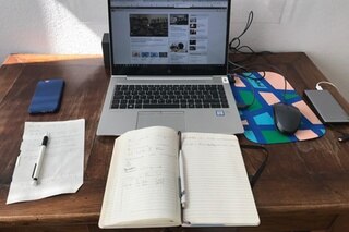 Arbeitsplatz mit Computer und offener Agenda auf dem Tisch