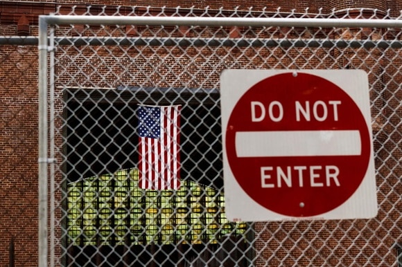 Immigrazione temporaneamente sospesa negli USA: nella foto un cartello con la scritta Do not enter con dietro la bandiera USA.