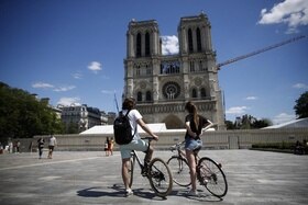 Due giovani in bicicletta fermi davanti alla cattedrale Notre Dame.
