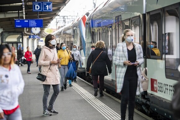 Stazione ferroviaria di Ginevra: tutte le persone indossano la mascherina sul viso.