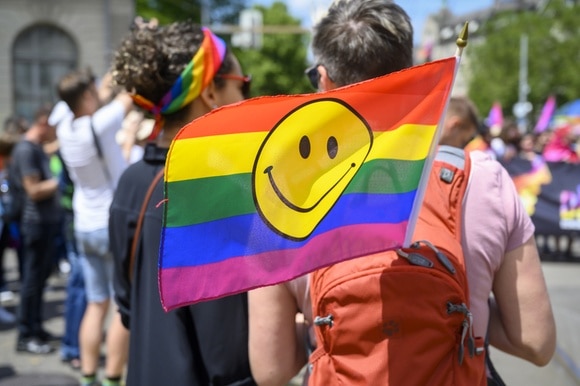 Una bandiera arcobaleno portato dietro nello zaino durante il gay pride 2019 di Zurigo
