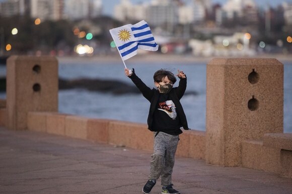 Un ragazzino con mascherina e bandiera dell Uruguay. Foto presa a Montvideo.