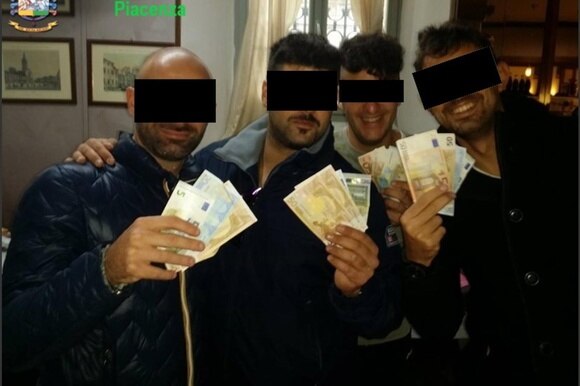 Quattro dei carabinieri fermati che esibiscono i proventi della loro attività criminosa