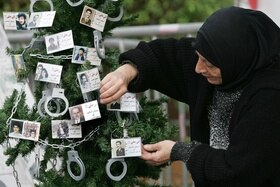 Albero con le foto di persone scomparse nel conflitto siriano.