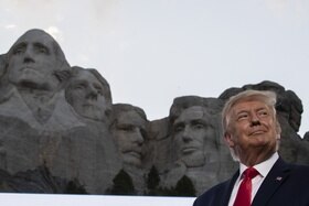 Donald Trump fotografato sotto il memoriale in modo tale per cui sembra il quinto presidente scolpito nella roccia.
