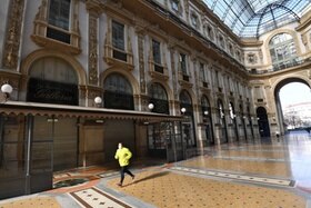 Una persona fa jogging in una galleria Vittorio Emanuele completamente vuota e chiusa.