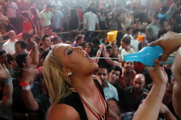 Una ragazza che beve canna da una bottiglia di superalcolico