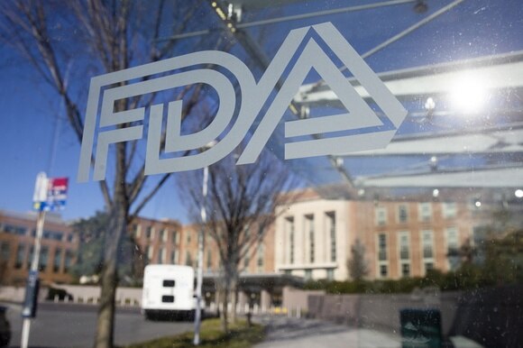 Stabile amministrativo con alte finestre visto attraverso un vetro con scritta FDA