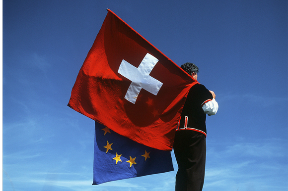 uomo con due bandiere: una dell ue e l altra della svizzera
