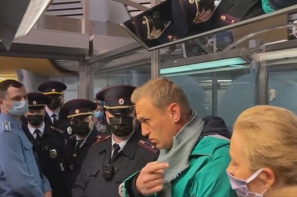 navalny attorniato da diversi poliziotti