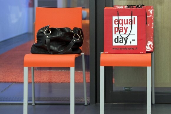 Una vorsa su una sedia con la scitta Equal pay day