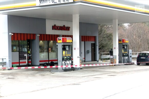 Immagine di un distributore di benzina con nastro della polizia a delimitare la zona