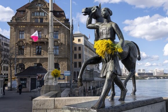 La statua di un amazzone con in mano delle vere mimose a Basilea.