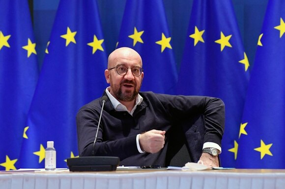 Charles Michel a un tavolo di conf stampa con baniere UE sul fondo, batte il gomito destro per sottolineare qualcosa