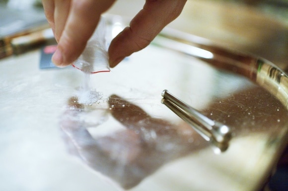 Una bustina di cocaina versata su un vassoio.