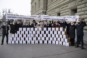 gruppo di persone con delle scatole contenenti le firme per il referendum
