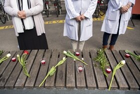 persone dietro a un banco con dei fiori e delle candele