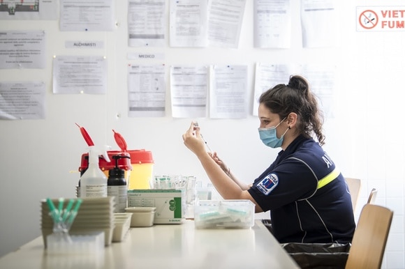 Una giovane paramedico prepara le dosi di vaccino da inoculare.