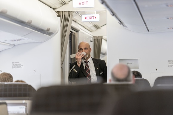 Uomo stewart annuncia qualcosa sul telefono di bordo dell aereo