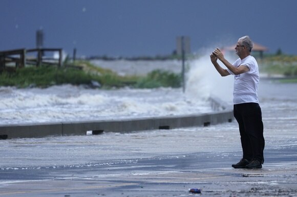 Un uomo fotografa la furia dell uragano.