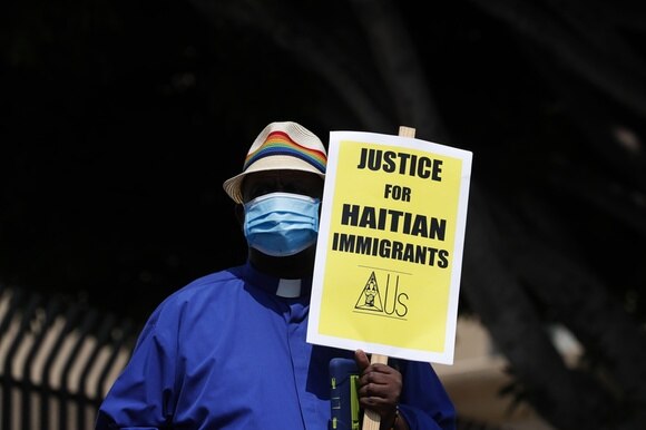 Un militante manifesta contro la politica migratoria americana e il trattamento dei migranti haitiani