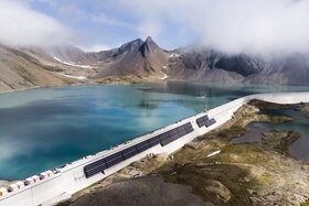 Pannelli solari sulle pareti in calcestruzzo della diga alpina.