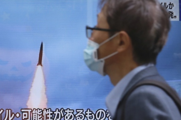 uomo guarda tv con immagine di un missile