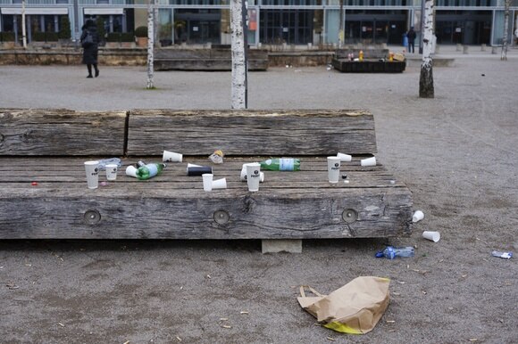 bicchieri e bottiglie abbandonati su una panchina