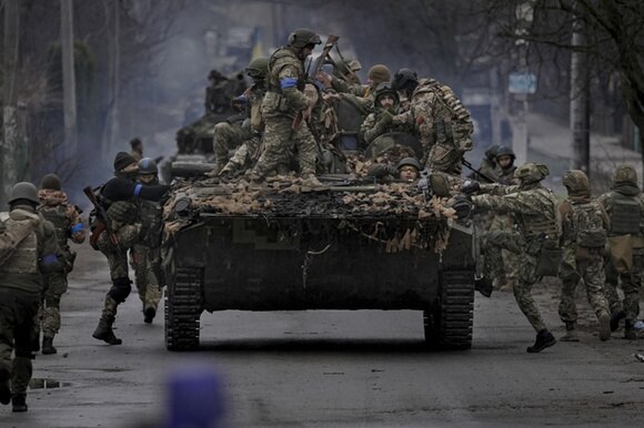 soldati salgono su un carro armato