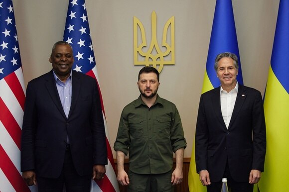 tre uomini davanti alle bandiere usa e ucraina