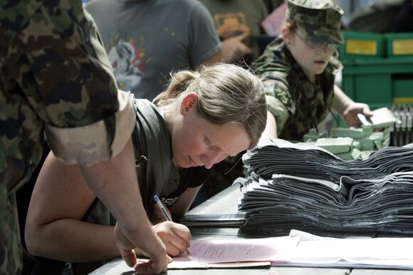 Swiss army female recruit signing a form