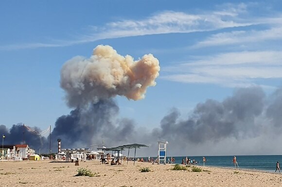 Una spiaggia vicina alla base russa: si vede un nuvolone di fumo.