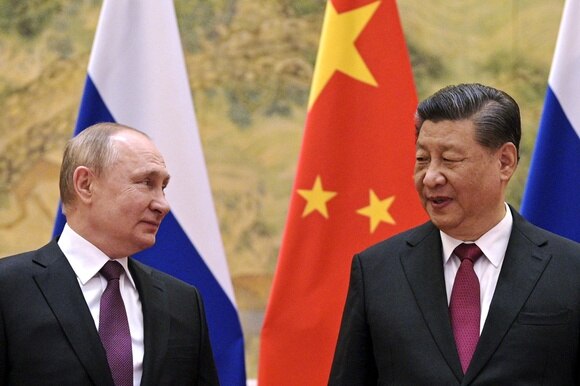 Putin e Xi davanti alle bandiere cinese e russa.