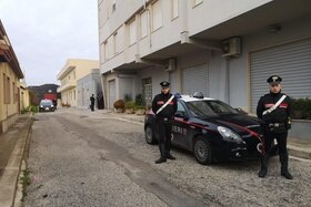 due carabinieri fanno la guardia davanti a un edificio