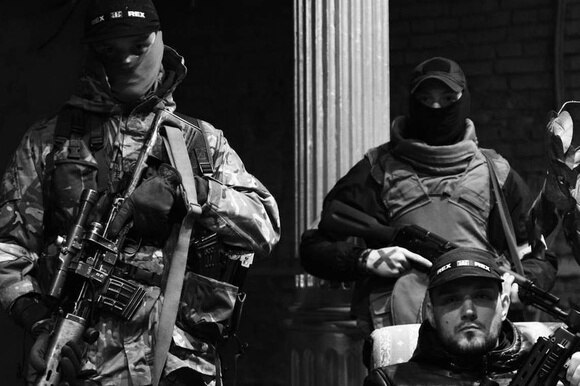 immagine in bianco e nero di uomini armati in tuta mimetica