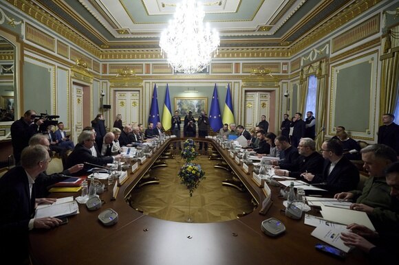 politici intorno a un grande tavolo. sullo sfondo bandiera ucraina e bandiera ue