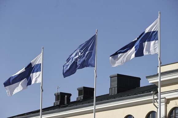 tre bandiere si stagliano contro il cielo azzurro: finlandiua, nato, finlandia