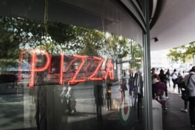 vetrina con scritta pizza fatta con neon rosso