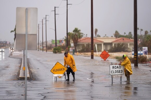 Tempesta Hillary in California, lavoratori bloccano una strada allagata.