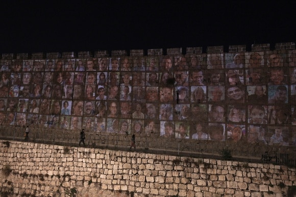 immagini delle persone rapite da hamas proiettate sulle mura di gerusalemme